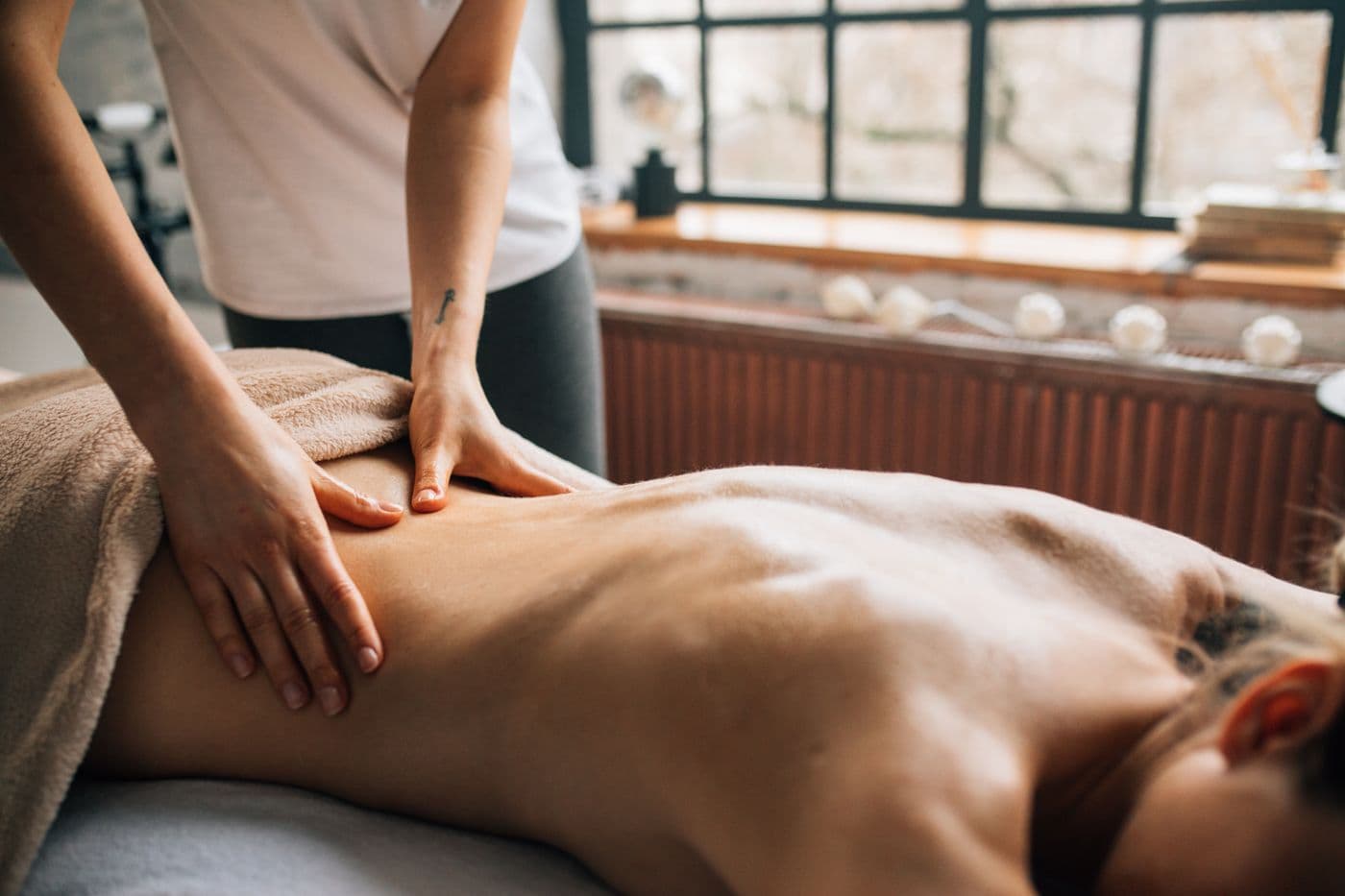 Masajista aplicando presión profunda sobre la espalda en un masaje deep tissue